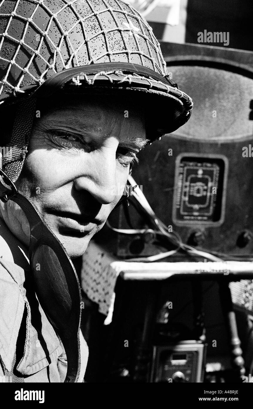 VE Day tribute fair (2005). Marine glances back as he sits listening to old wireless set. Stock Photo