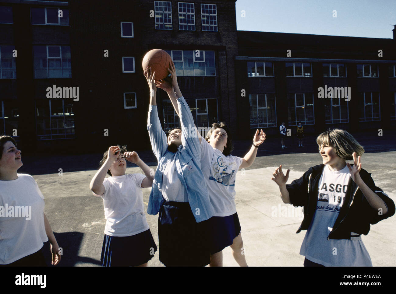 TEENAGE PUPIL PLAYING NETBALL IN SCHOOL PLAYGROUND. GLASGOW HOLYROOD SECONDARY SCHOOL, MAY 1990. Stock Photo