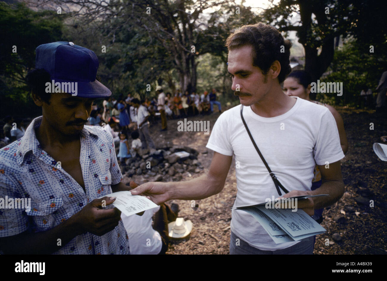 Boaco, Nicaragua, June 1981; A government employee distributing handbills about adult literacy to a gathering in a rural community. Stock Photo