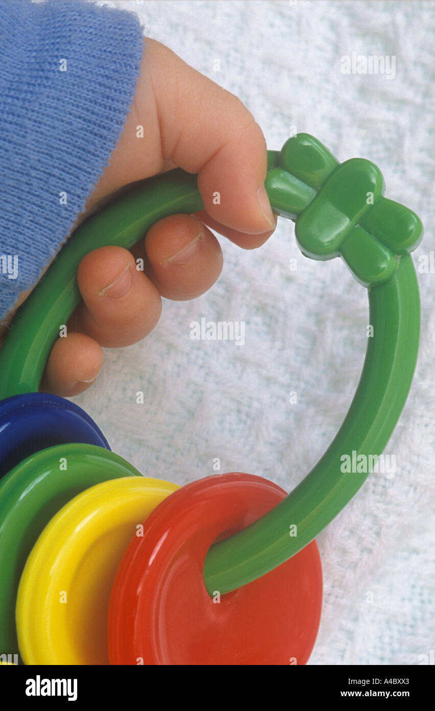 Infant Hand With Toy Rattle Detail Close Up Stock Photo