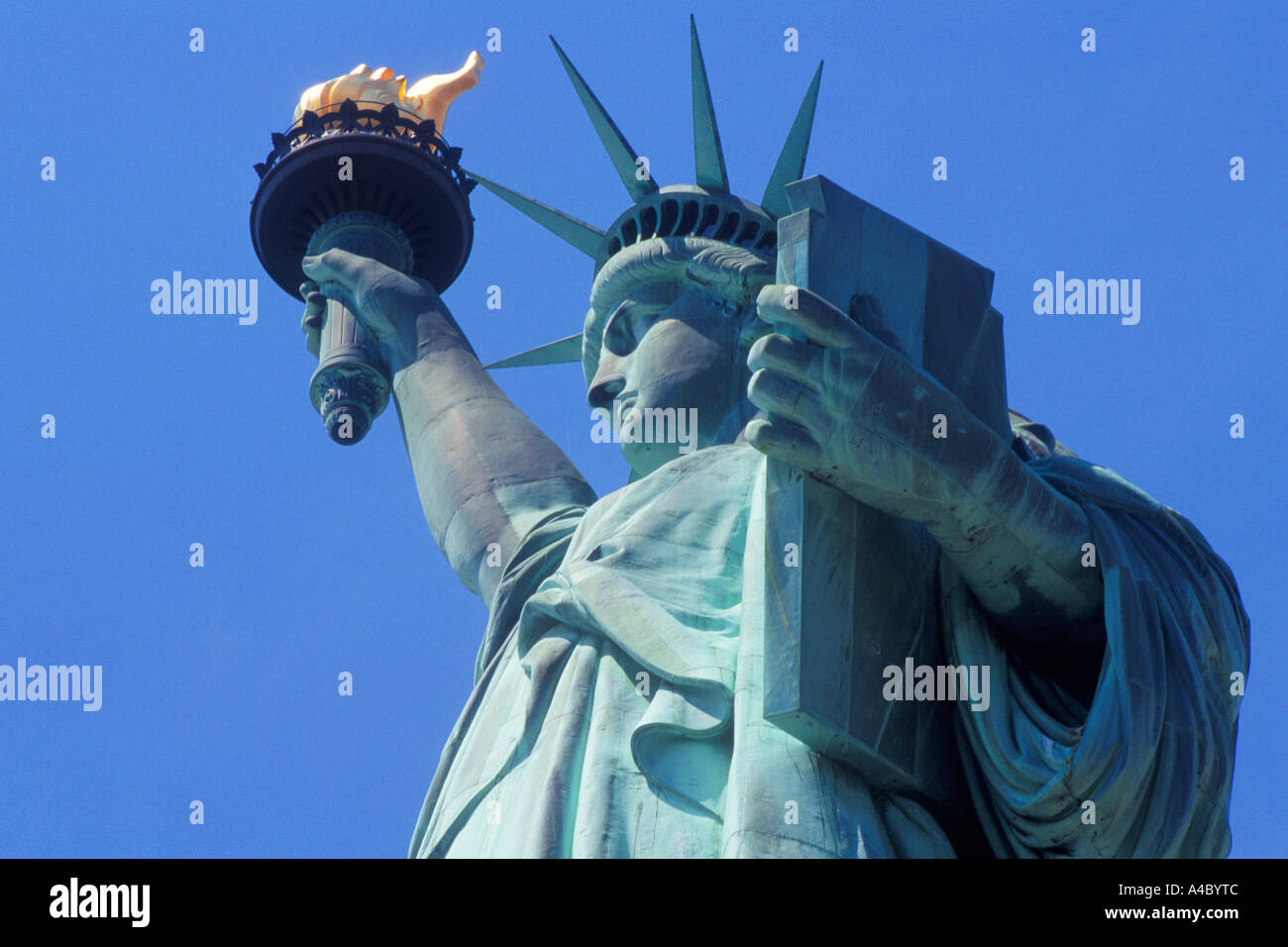 Statue of Liberty New York close up. Low angle view of upper body, head, torch, flame, tablet, crown. Historic monument in Lower Manhattan, USA Stock Photo