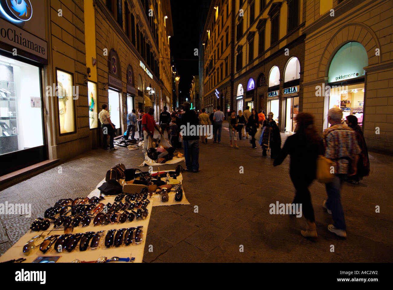 Hawkers selling fake handbags in the centre of Florence at night Italy EU Europe Firenze Stock Photo