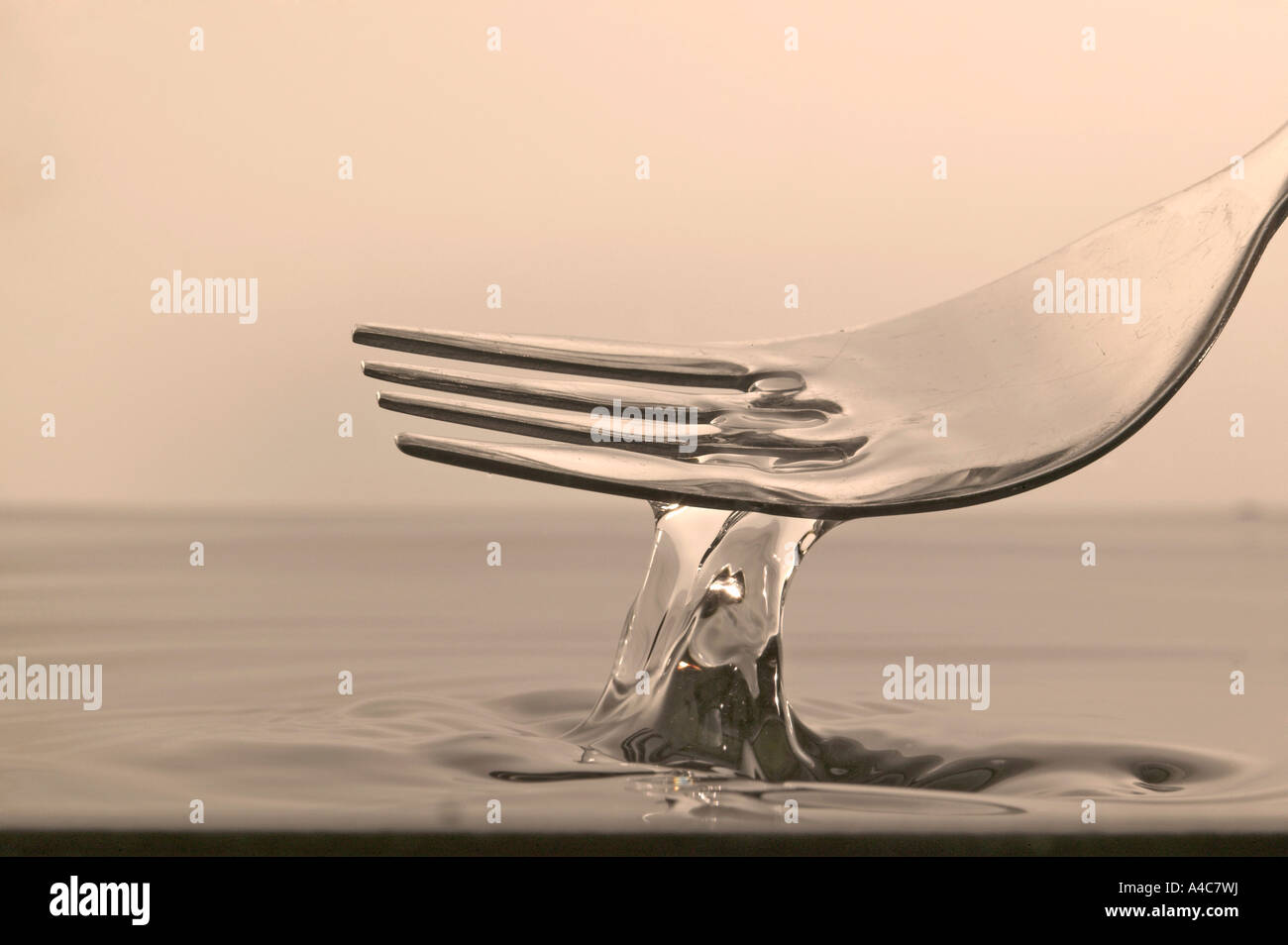 Fork and water. Wrong tool for job, tinted sepia Stock Photo