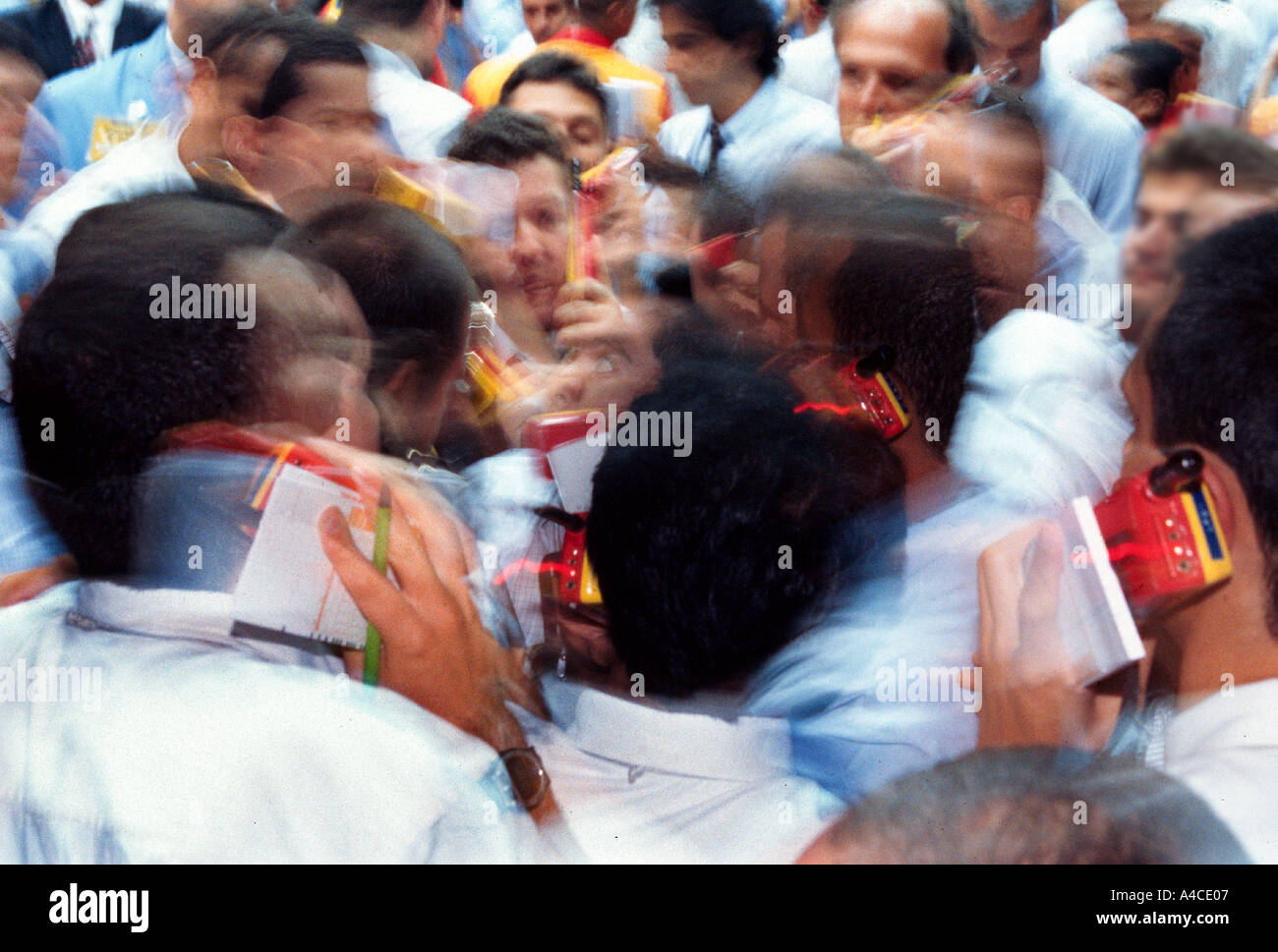 Stock market pit traders with phones are a blur of activity Stock Photo