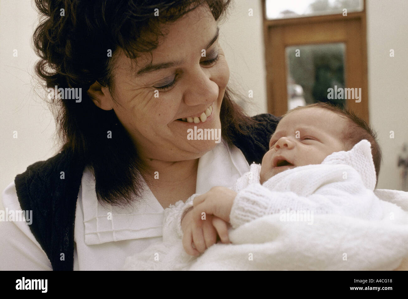 An inmate holds her baby son wrapped in a blanket.' Stock Photo