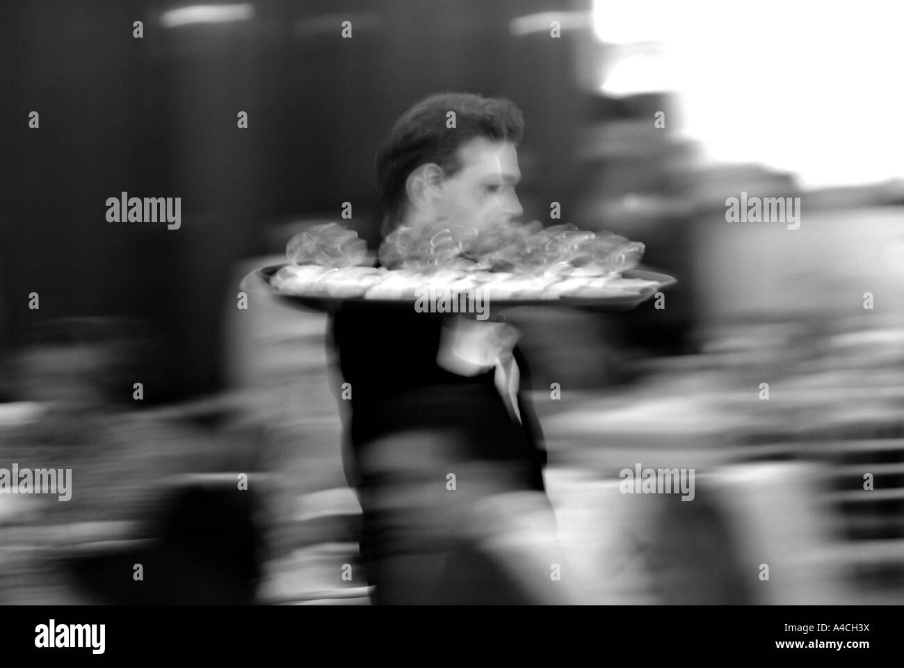 Waiter with tray of food blurred Stock Photo