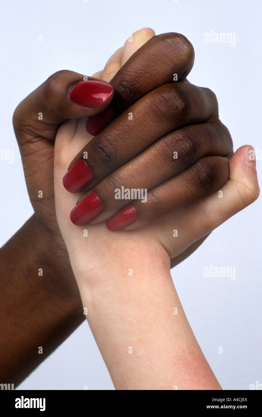 Black and white hands clasped in harmony and friendship - or fighting Stock Photo