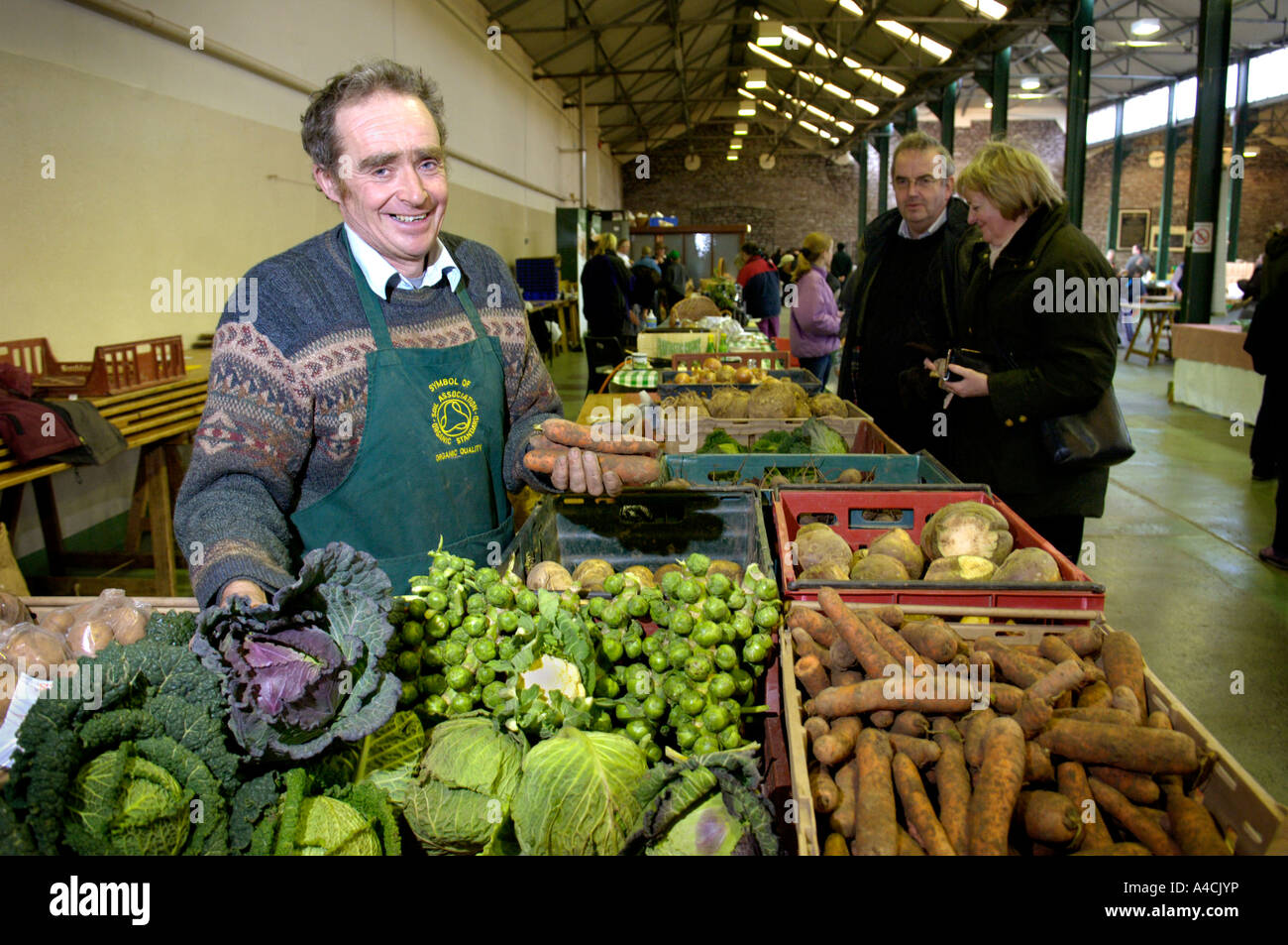 Farmers market trader selling organic vegetables and fruit Brecon Wales