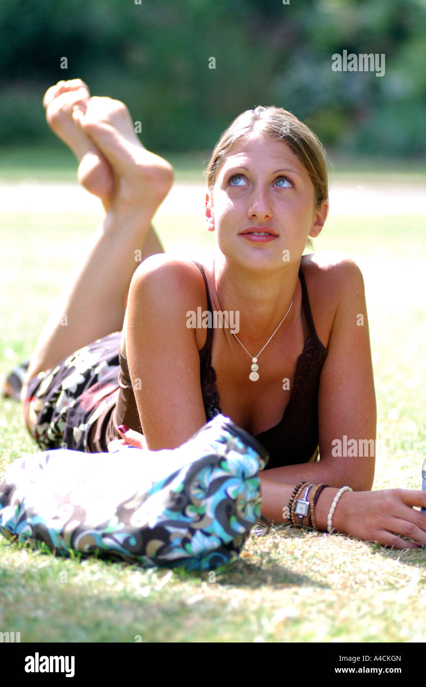 Royalty free photograph of British college student relaxing barefoot in London park UK in the summer sunshine Stock Photo