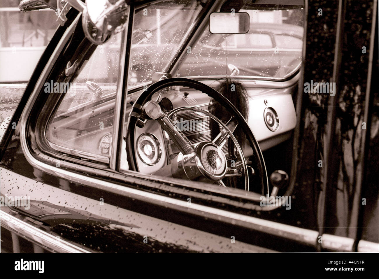 Through the driver's window of a 1950s classic American car on a rainy ...
