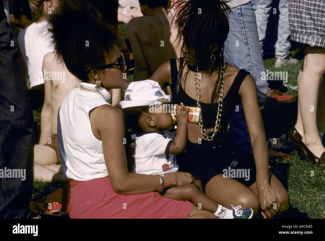 ROCK CONCERT, BATTERSEA PARK, LONDON, ENGLAND.  TWO  WOMEN WITH A BABY, 1988 Stock Photo
