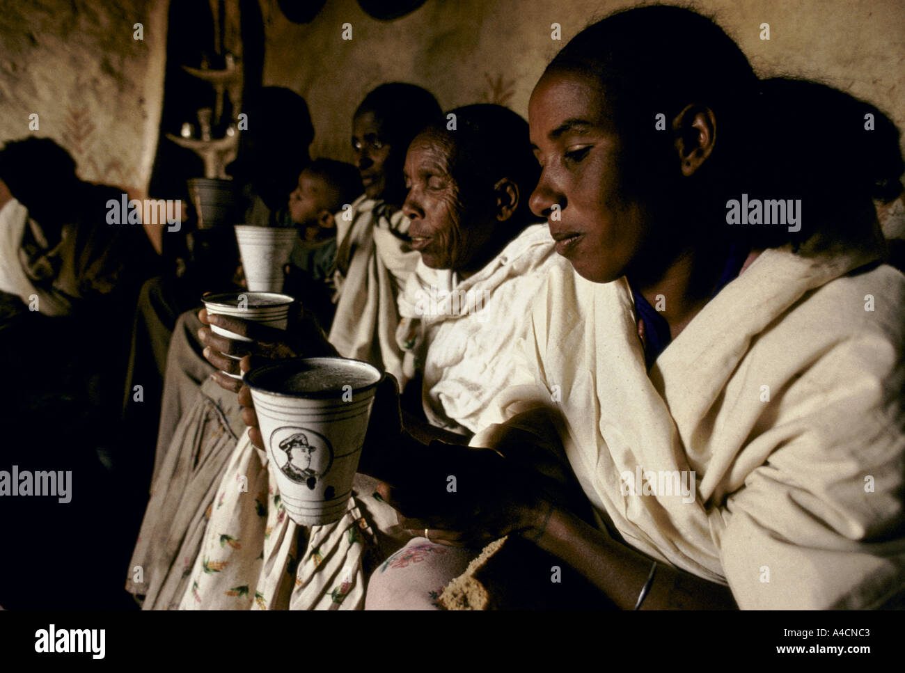 GROUP OF MEN & WOMEN, DRINKING FROM ENAMEL BEAKERS DURING A SOCIAL