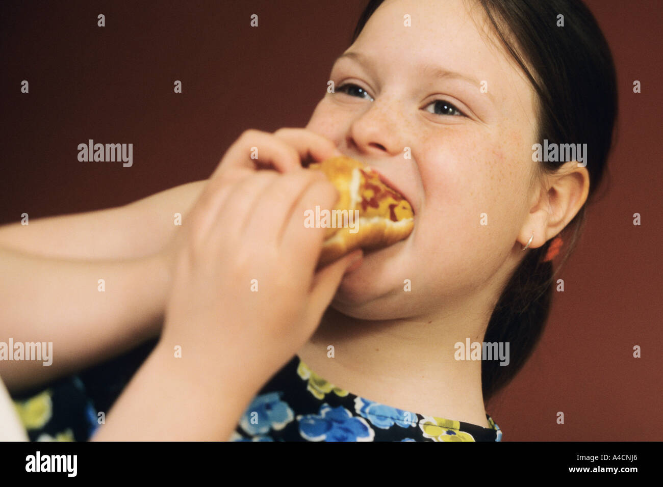 11 year old girl eating a hotdog Stock Photo