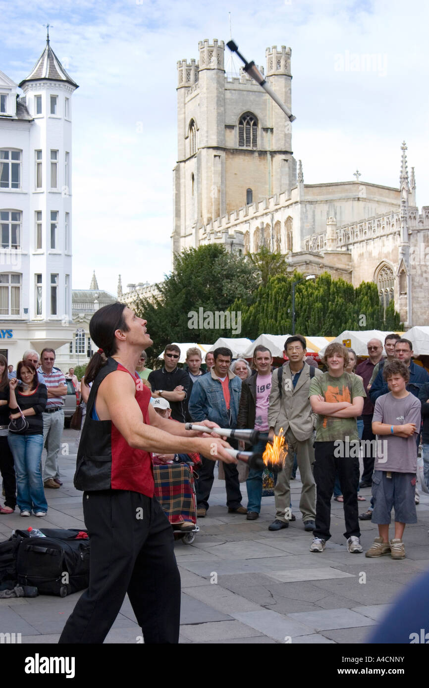 Street performer juggling with fire in Cambridge market square, England Stock Photo