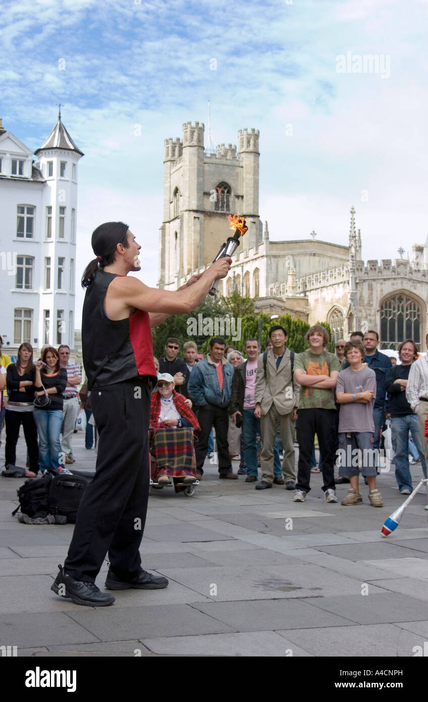 Street performer juggles with fire in Cambridge market square, England Stock Photo