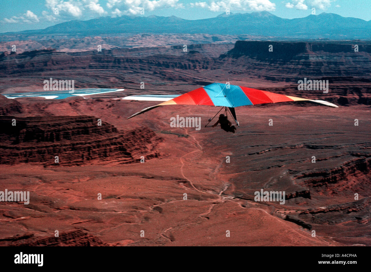 A hang glider flies through the air currents at Dead Horse Point outside of Moab Utah Stock Photo