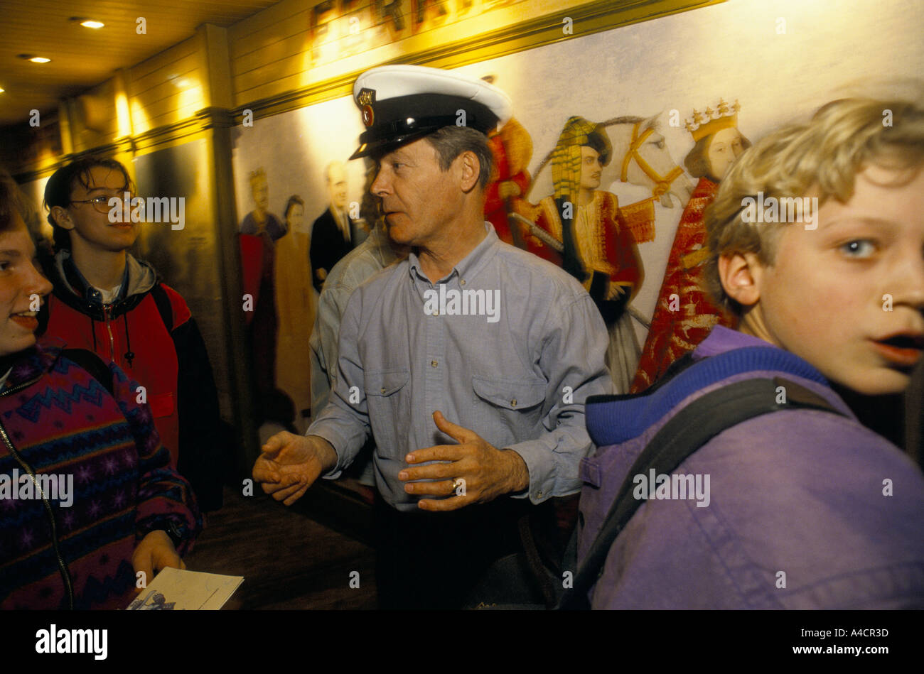 CHILDREN ENJOYING THE DISPLAYS AT THE WHITE CLIFFS EXPERIENCE IN DOVER, MAN WITH CAPTAIN HAT TALKING TO BOYS. DOVER, ENGLAND, MA Stock Photo