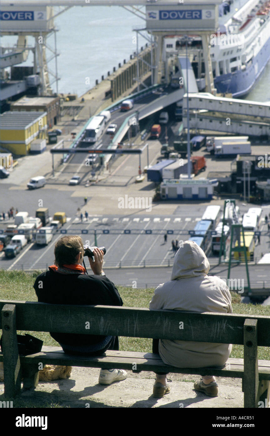 People watch cars loading in ferry boat bound for Calais in Dover's car and truck ferry terminal on England's south east coast Stock Photo