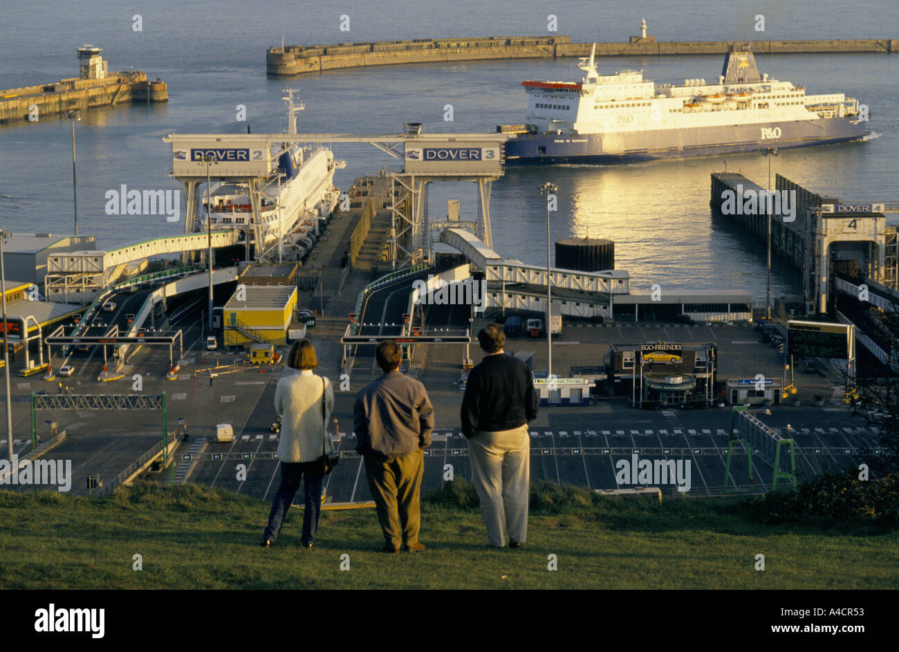 People watch cars loading in ferry boat bound for Calais in Dover's car and truck ferry terminal on England's south east coast Stock Photo