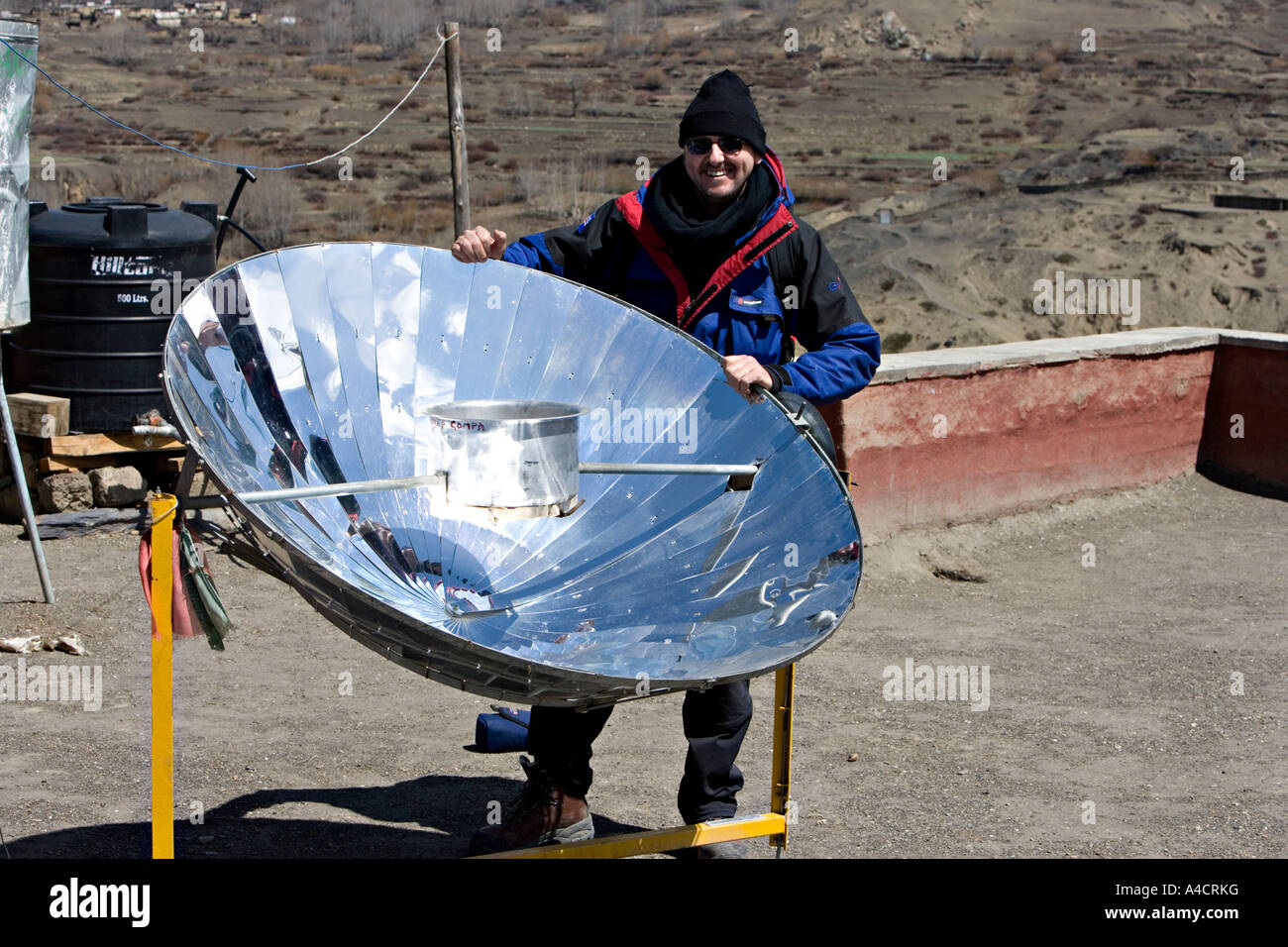 Tourist looks over solar heater in the Himalayan mountains, Nepal Stock Photo