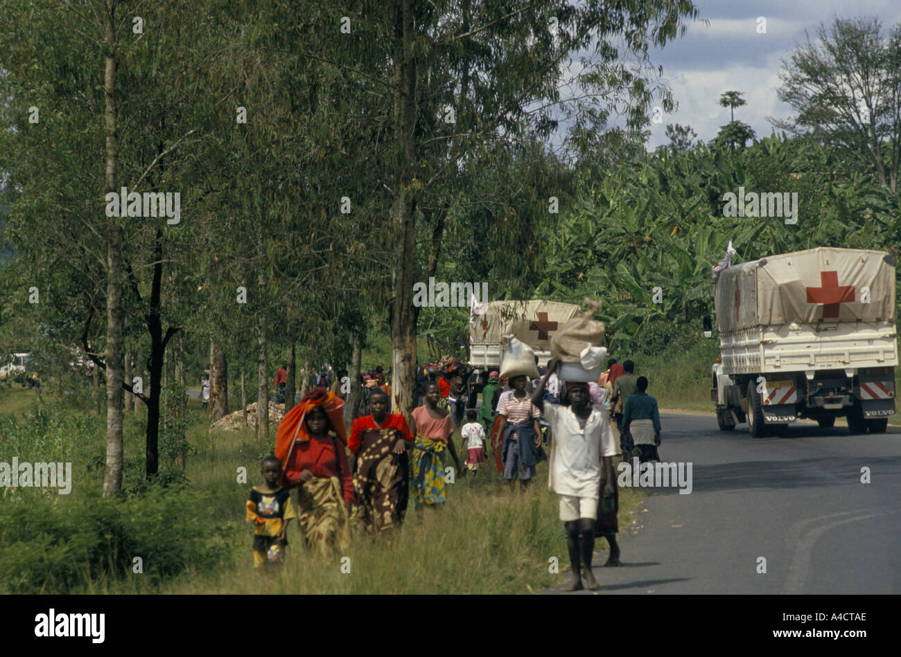 'RWANDAN CIVIL WAR', INTERNATIONAL RED CROSS CONVOY BRINGING IN MEDICAL SUPPLIES TO KIGALI NEARS THE TOWN AND REFUGEES FLEE IN THE OPPOSITE DIRECTION. april 1994 Stock Photo