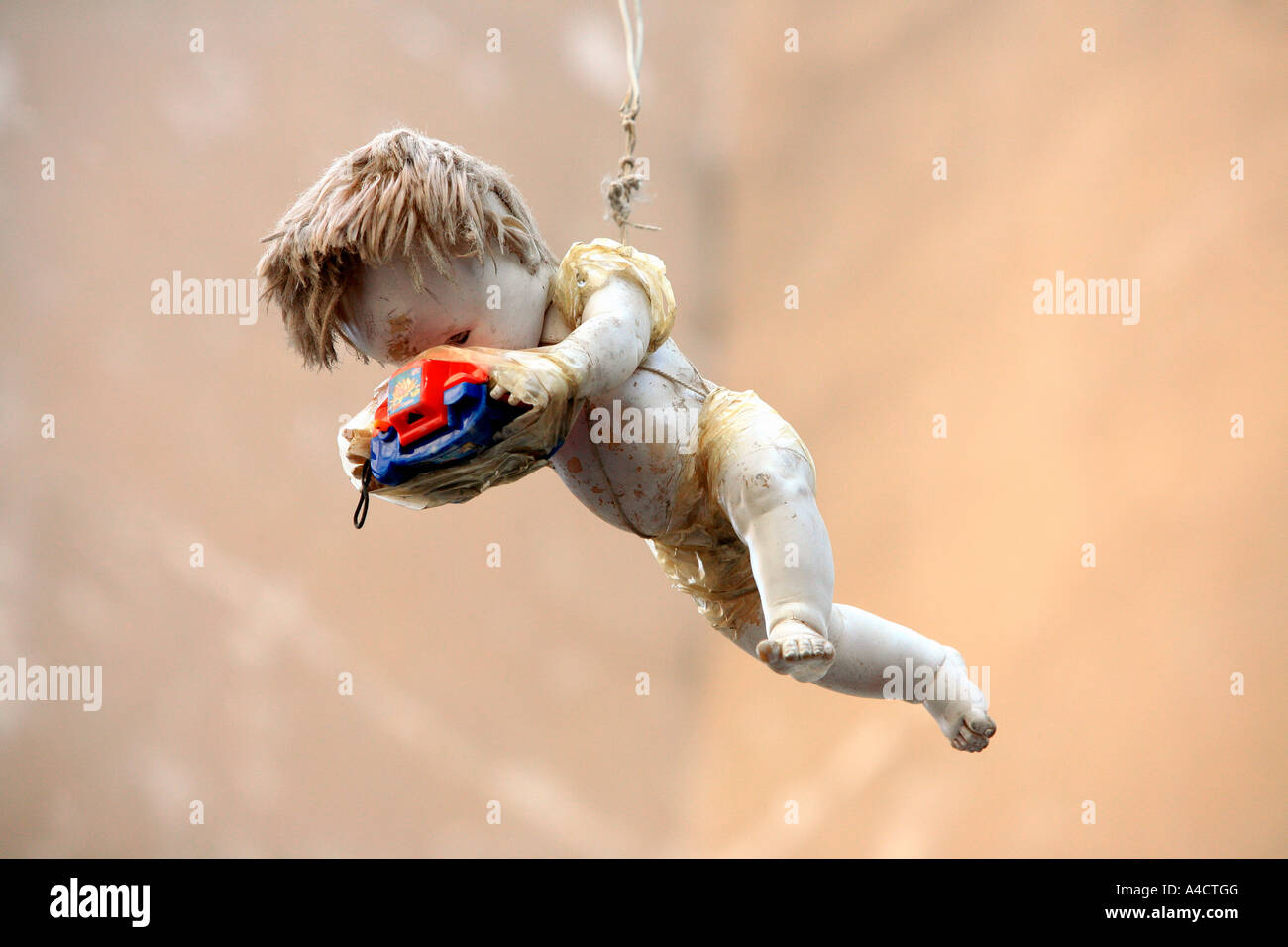 Old doll holding Viewmaster hanging in the air Stock Photo