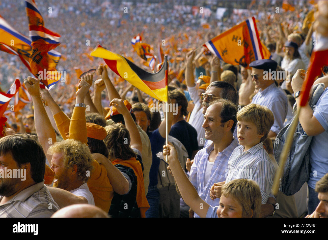 A crowd of Dutch and German football fans stand, chanting and waving Stock Photo 3594746 Alamy