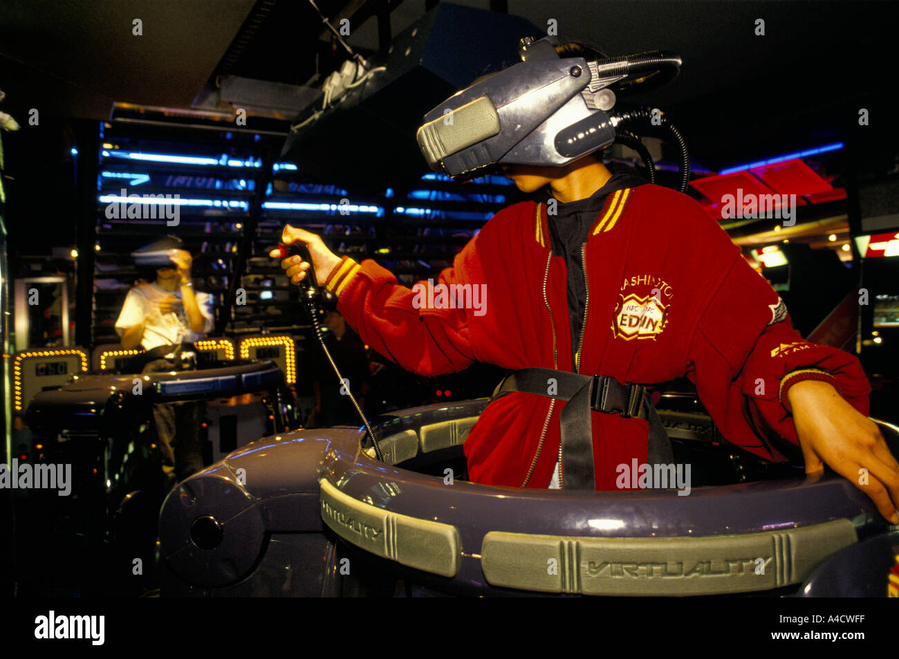 A boy wears a 3D visor to play a virtual reality video game in three
