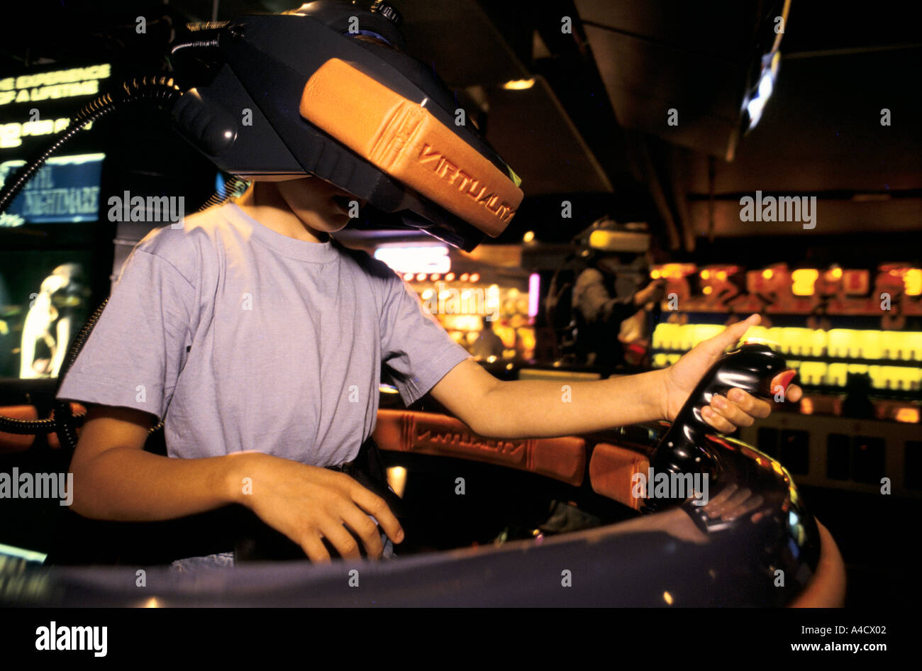 A girl wears a 3D visor to play a virtual reality video game in three dimensions at a games franchise in the Trocadero Centre Stock Photo
