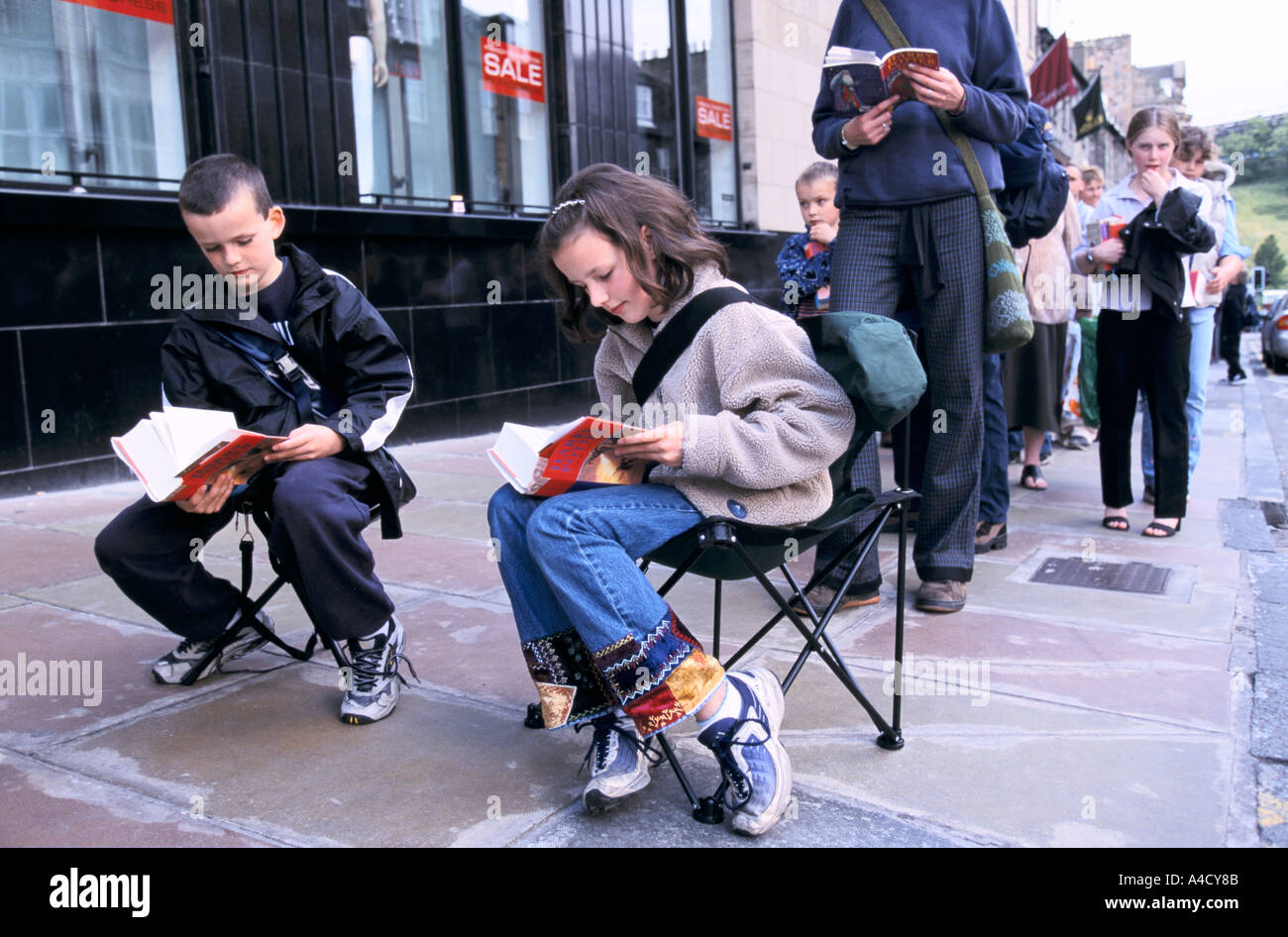 A queue of Harry Potter fans wait outside the book store for J K Rowling to sign a book. Edinburgh, Scotland 2000 Stock Photo