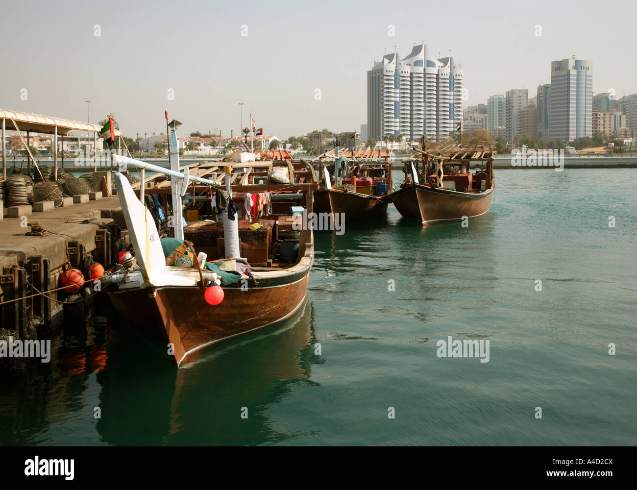 Traditional dhows in the harbour and modern buildings on the skyline, skyline, Abu Dhabi city, UAE Stock Photo