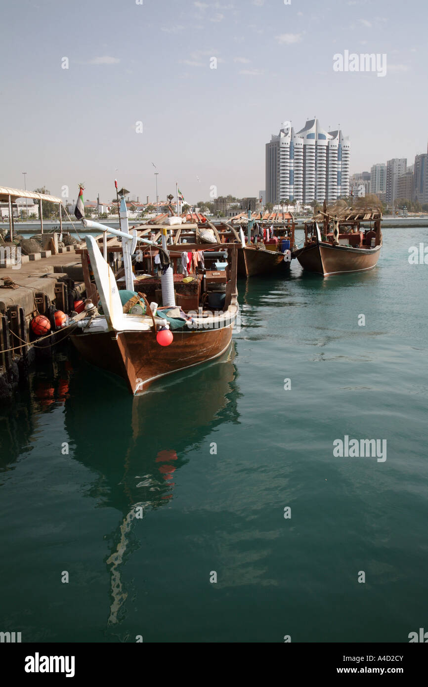 Dhows in the harbour against the modern city skyline, Abu Dhabi dhow port, UAE Stock Photo