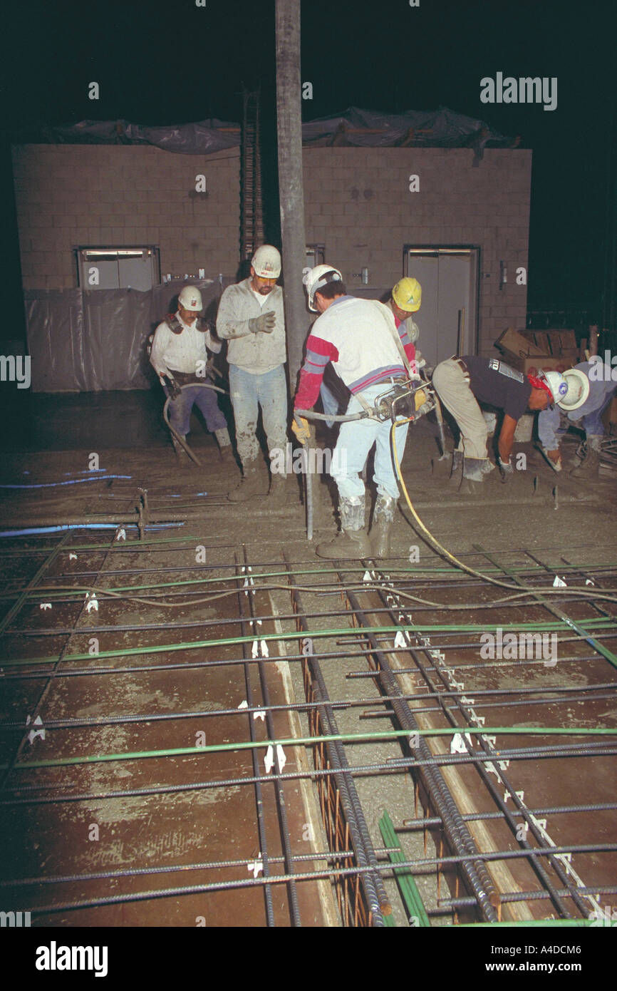 Construction Worker Vibrating Poured Concrete To Remove Air Bubbles