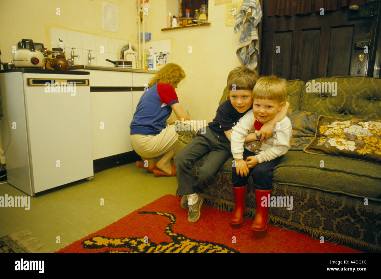 A homeless mother and her children in a hostel  kitchen, London Stock Photo