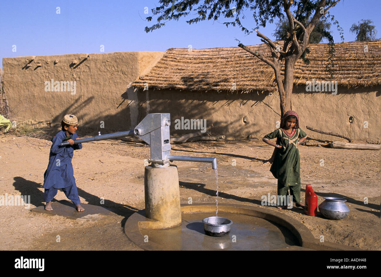 Village children use a water hand pump. Karchat area, Sindh province