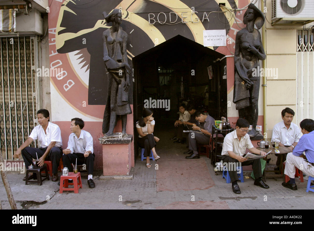 Workers taking early morning tea at a pavement cafe, Binh Tay Market, Saigon, Vietnam Stock Photo