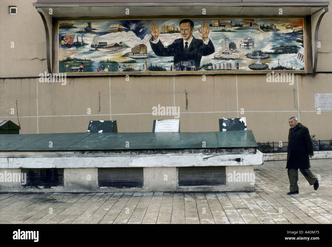 The personality cult of Assad. A man walking past a mural of Assad during the referendum campaign damascus december 1991 Stock Photo