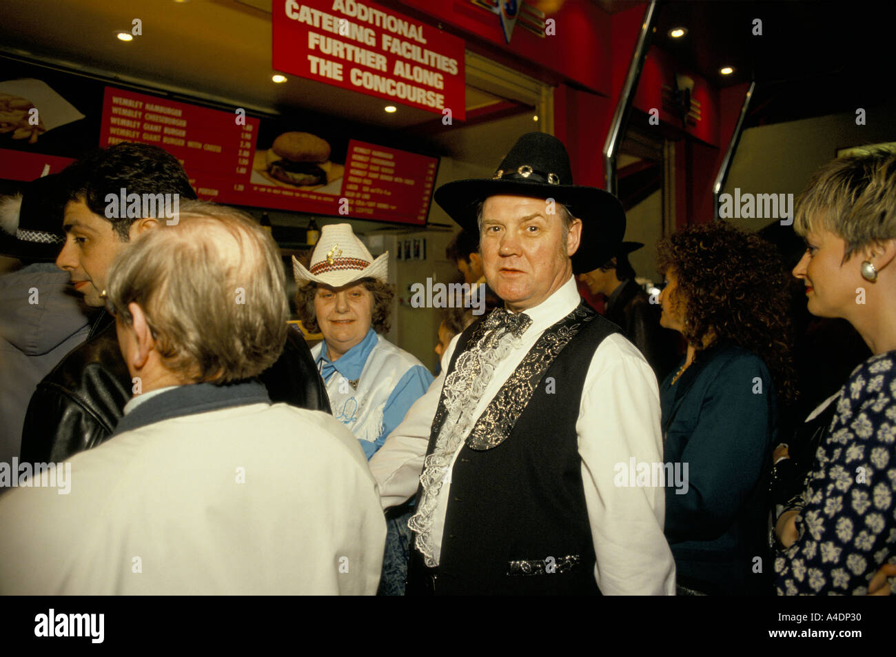 Fans wearing cowboy western style clothing at the Festival of Country Music Wembley Stock Photo