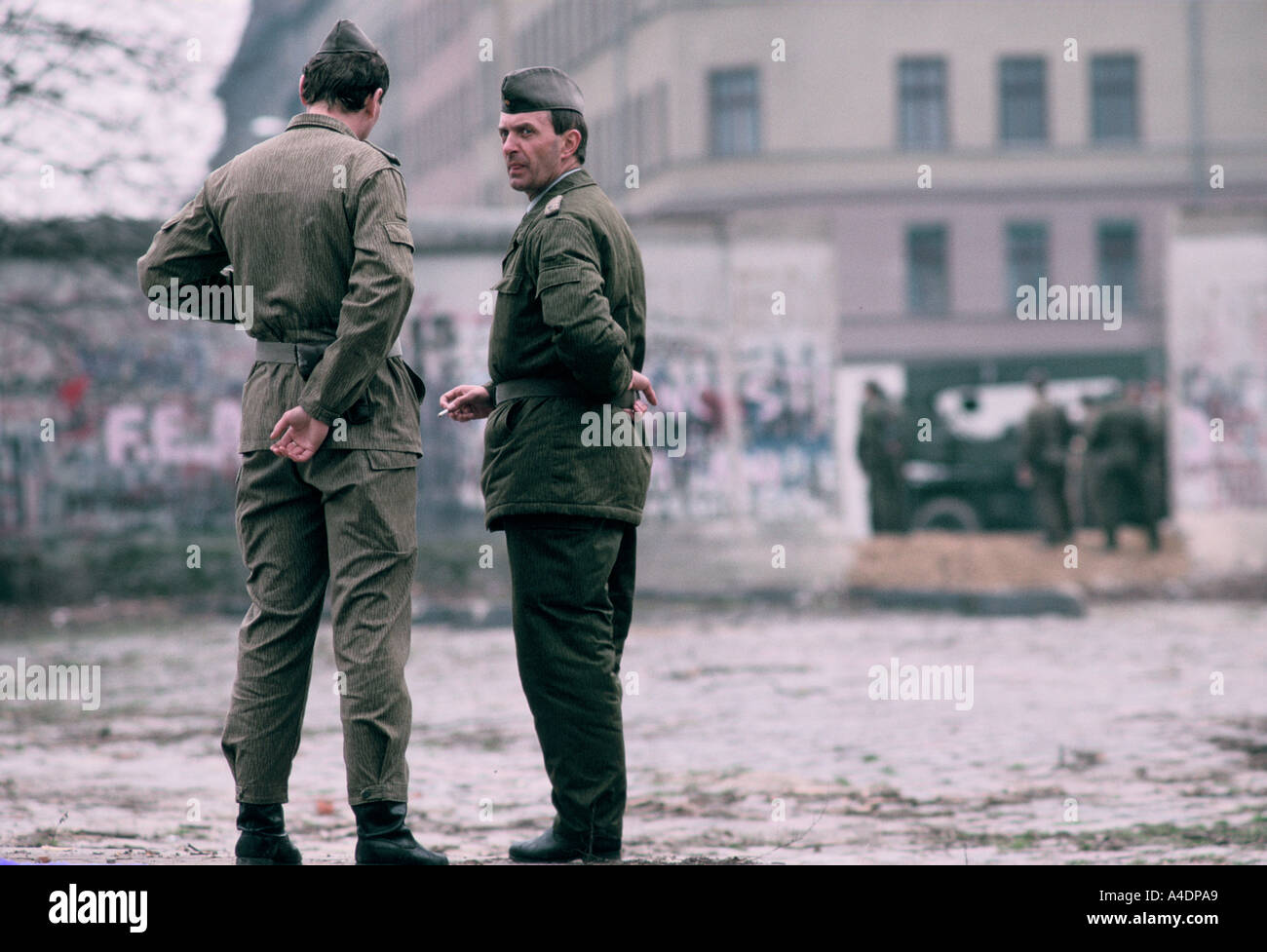 East German border guards crossing through a break in the wall, 1989
