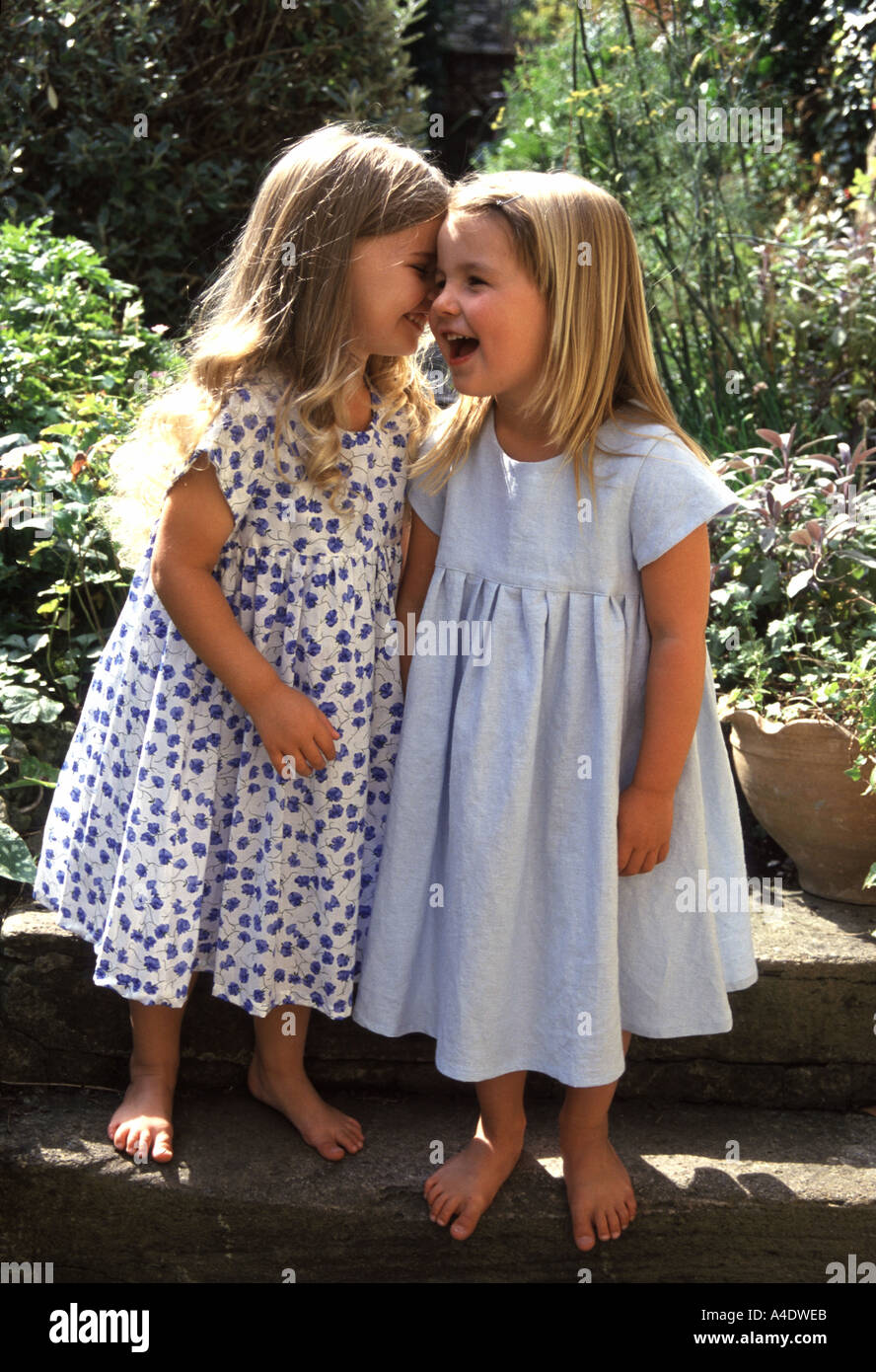 Two little girls whispering together Stock Photo - Alamy