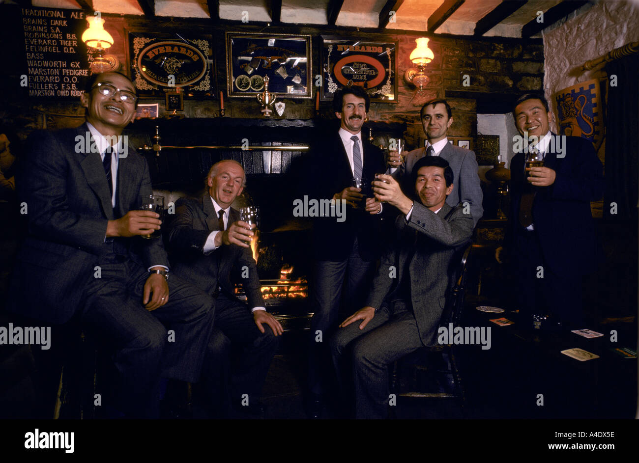 Men drinking raising glasses inside a pub in London, UK Stock Photo