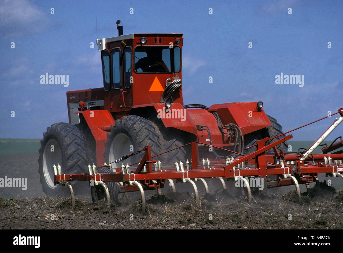 4 wheel drive agricultural tractor pulling spring tooth harrow Stock