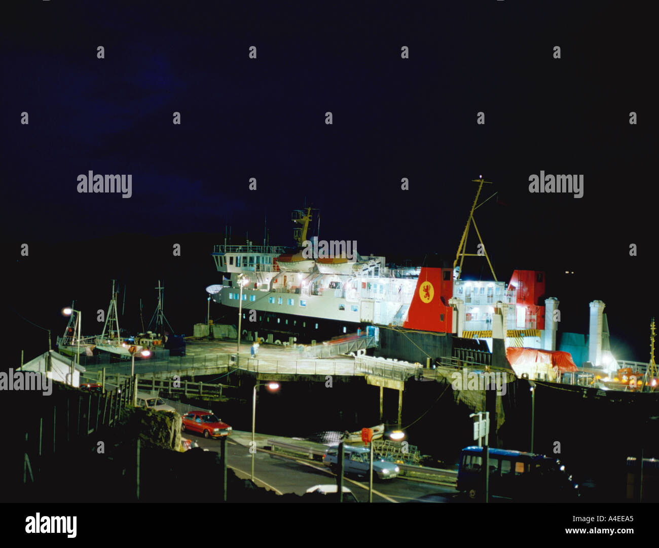 Cars disembarking from a roll on roll off ferry at night; Caledonian MacBrayne ferry at Barra, Outer Hebrides, Scotland, UK. Stock Photo