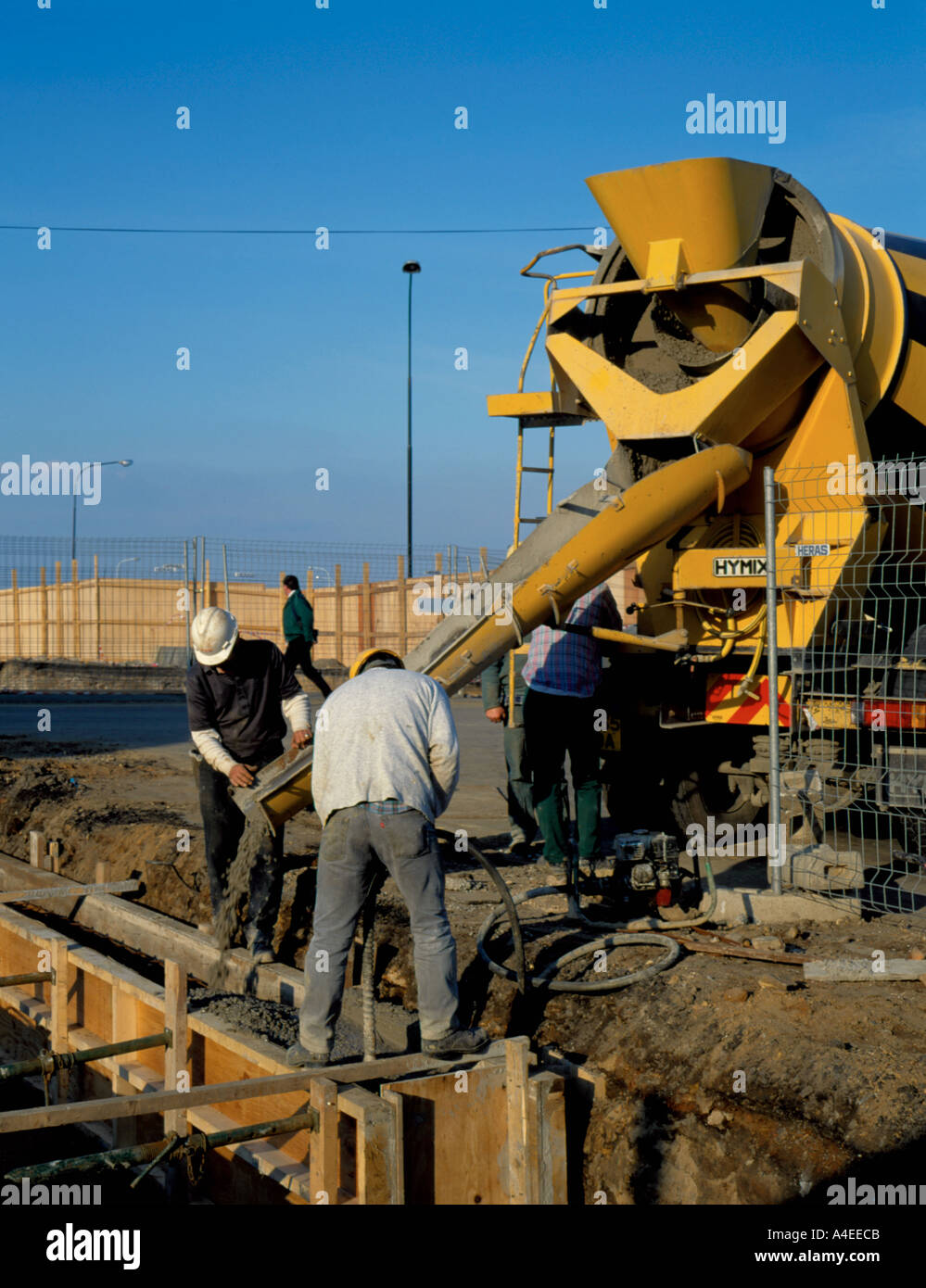 Pouring concrete from a ready mix concrete wagon to form a building foundation. Stock Photo