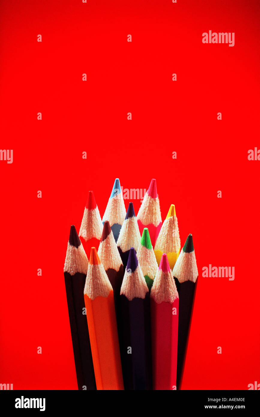 Twelve coloured crayons on red background Stock Photo