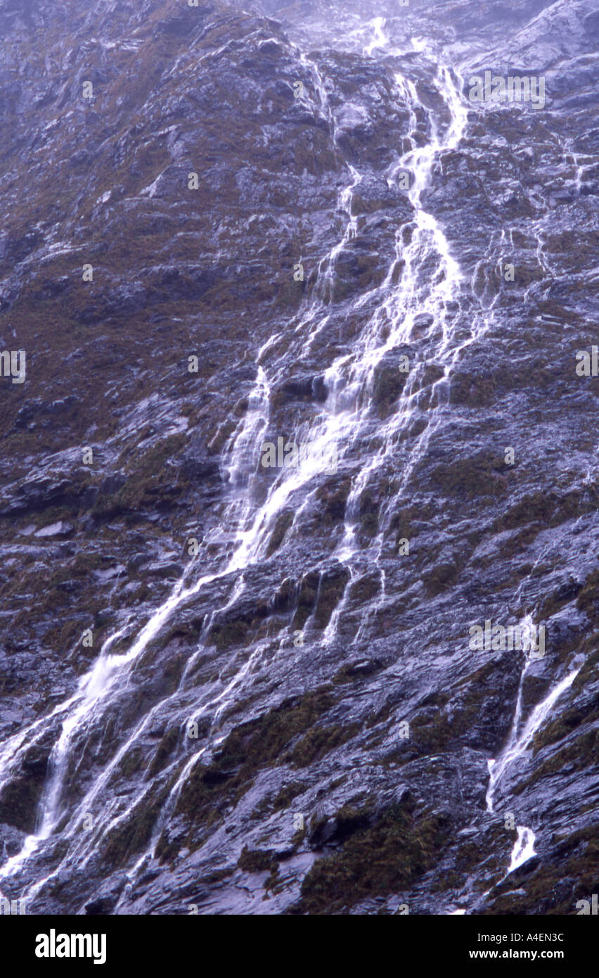 Abstract detail water cascades down the sheer walls of granite in Fiordland New Zealand after heavy rain Stock Photo