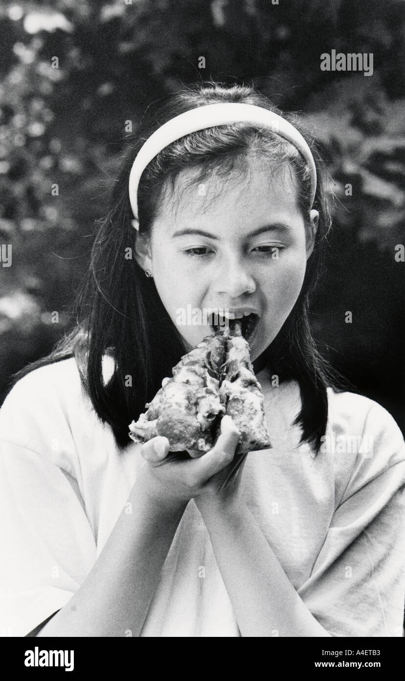 5599 10 Thirteen year old girl eats a slice of pizza San Francisco California USA MR 1 Stock Photo