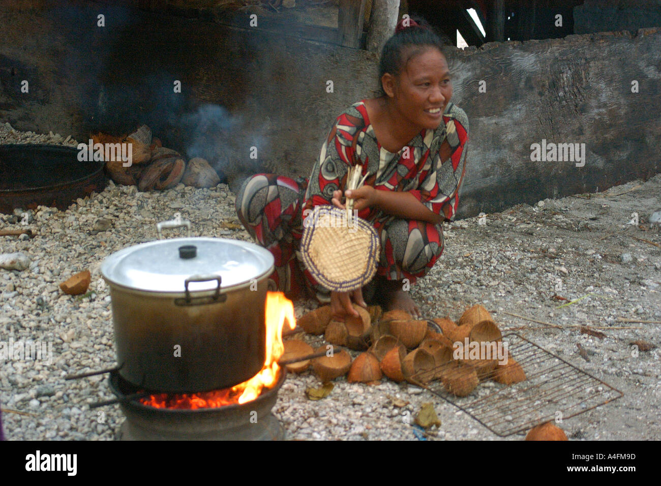 Marshalhese lady cooking in traditional coconut stove Majikin island Namu atoll Marshall Islands N Pacific Stock Photo