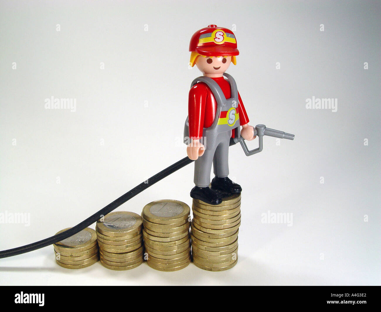 Service station attendant on a pile euro coins as symbol for the rising fuel prices Stock Photo