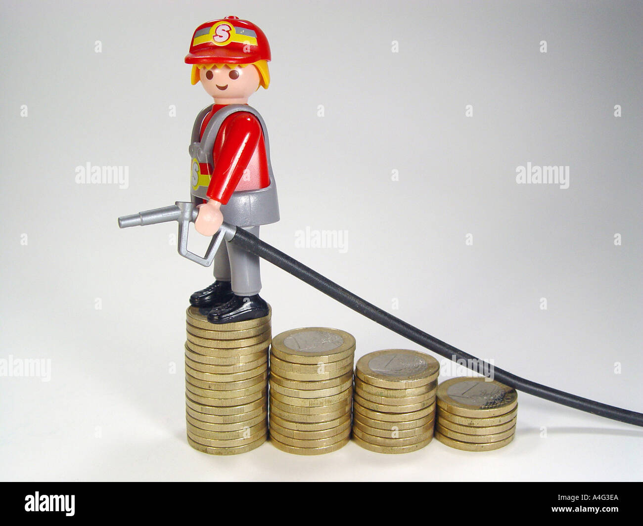 Service station attendant on a pile euro coins as symbol for the rising fuel prices Stock Photo